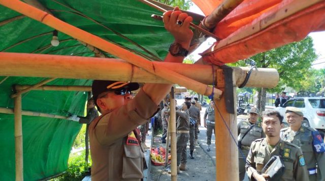 Anggota Satpol PP saat membongkar