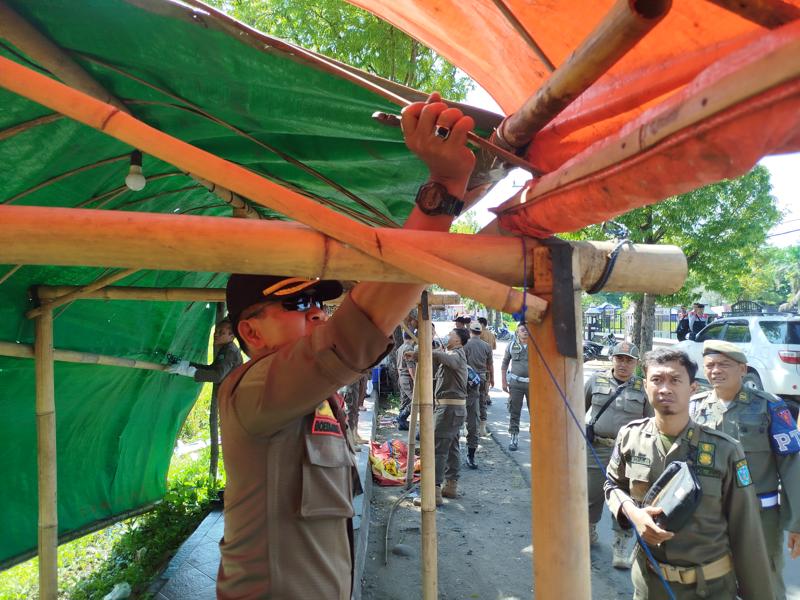 Anggota Satpol PP saat membongkar