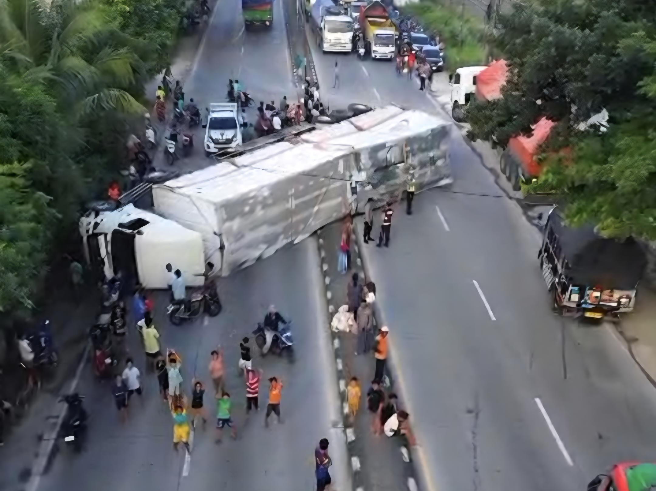 Tangkap layar rekaman dari video tampak  Truk Muatan Sabun Terguling melintang menutup jalan.