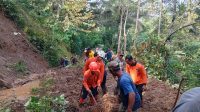 Petugas tim gabungan membersihkan longsoran.