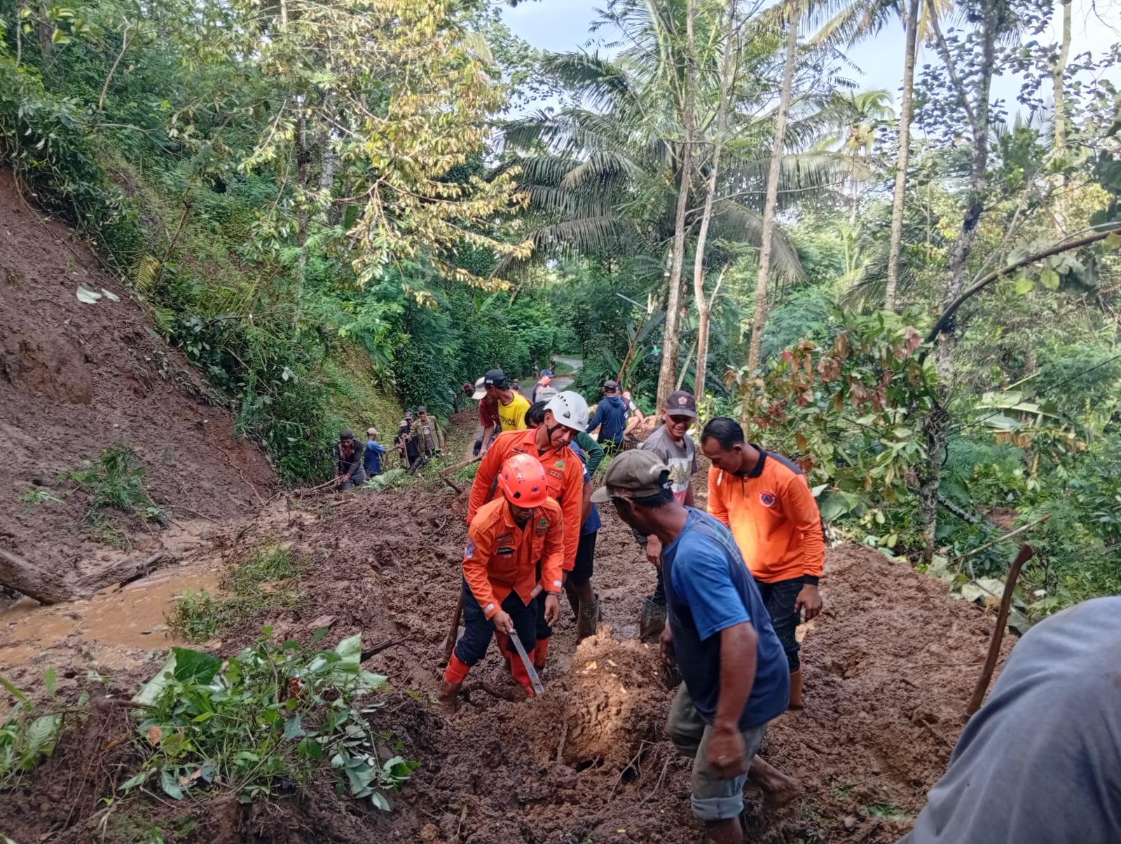 Petugas tim gabungan membersihkan longsoran.