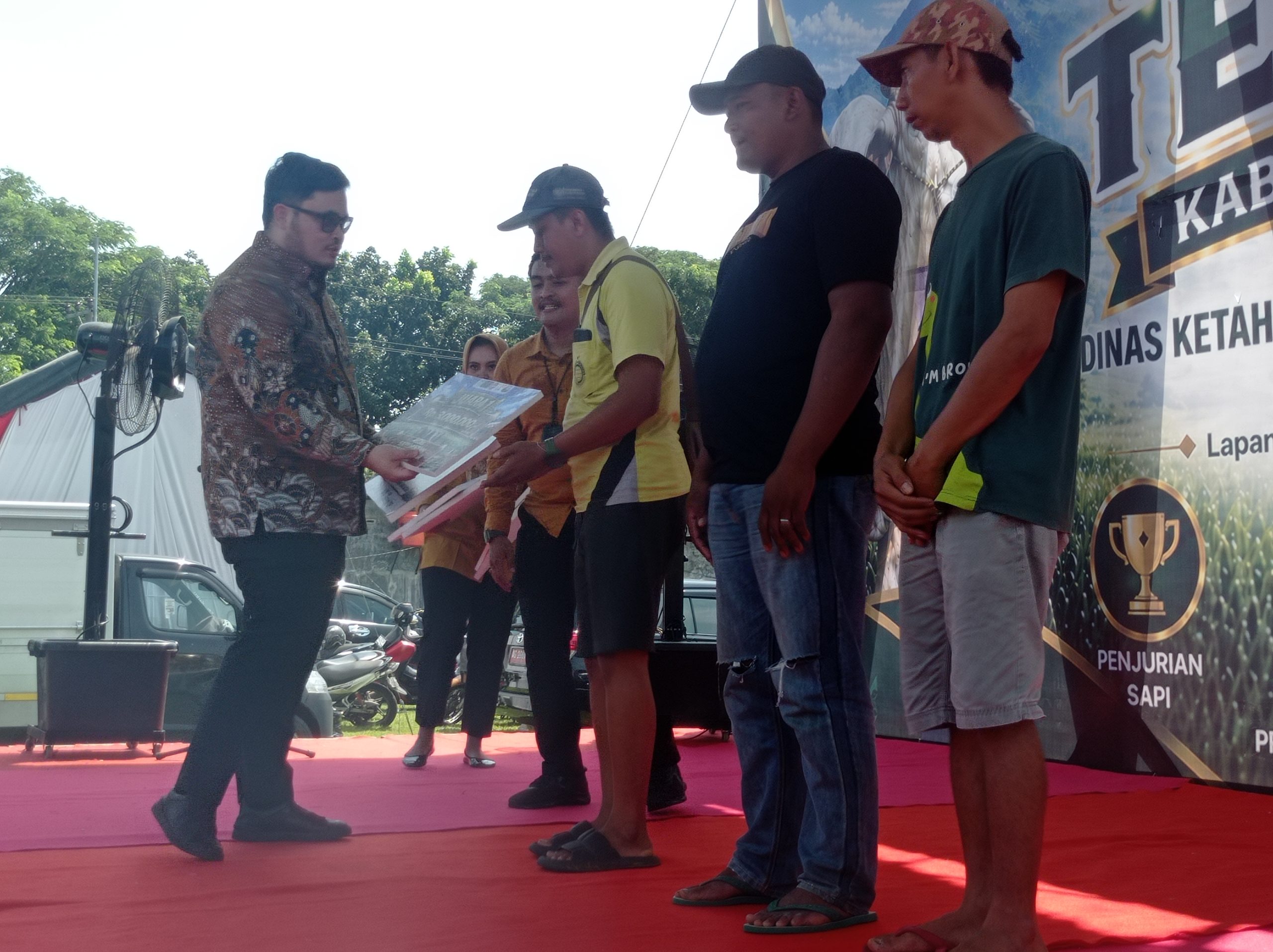 Bupati Kediri menyerahkan predikat juara di kontes ternak untuk katagori sapi kereman ektrem .