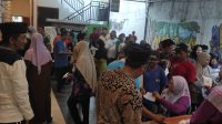 Ratusan warga Kepatihan saat mengantri mendapatkan bantuan di halaman balai desa.
