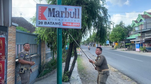 Petugas Satpol PP Tulungagung saat melakukan penertiban papan reklame rokok ilegal.