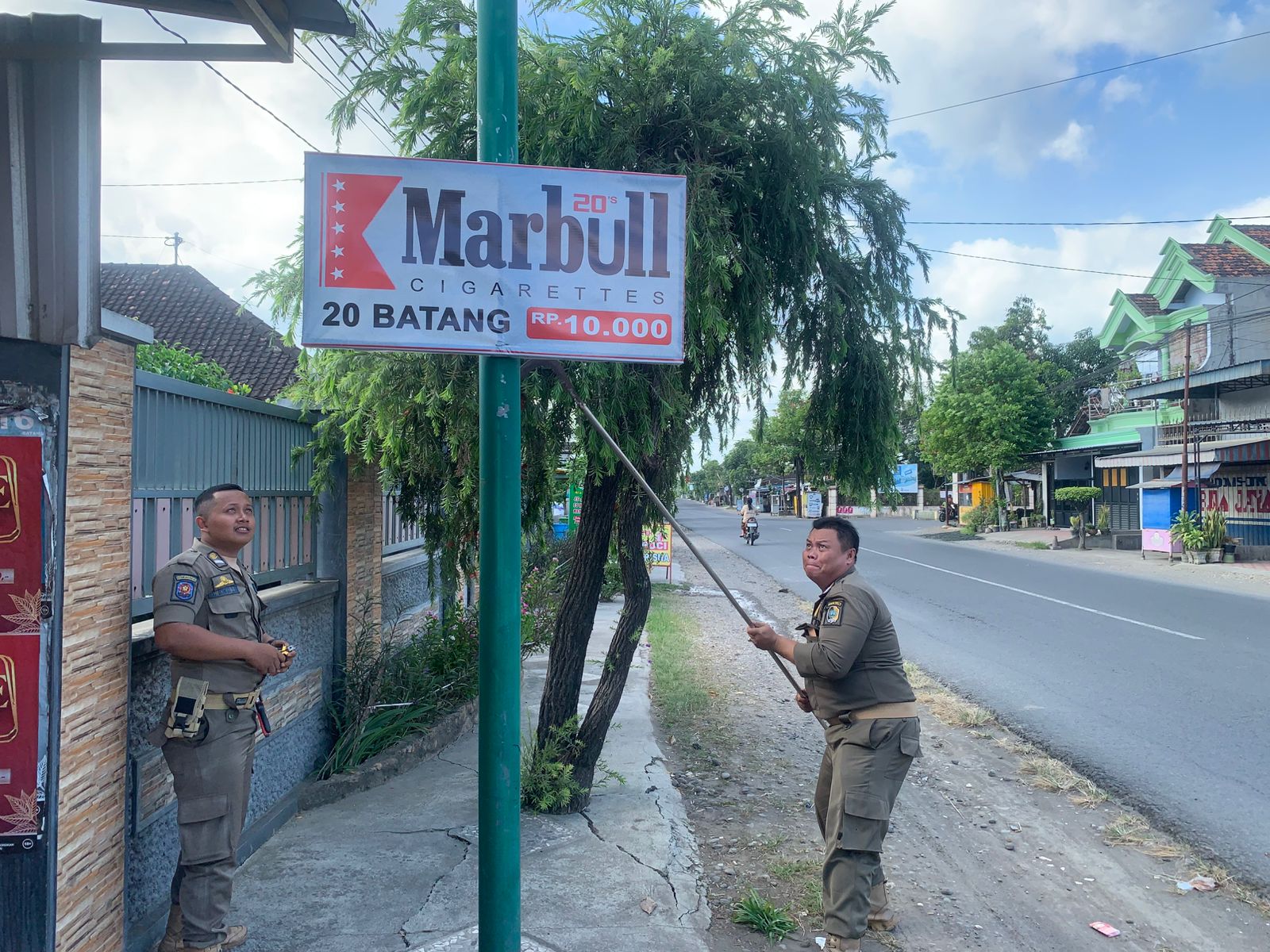 Petugas Satpol PP Tulungagung saat melakukan penertiban papan reklame rokok ilegal.