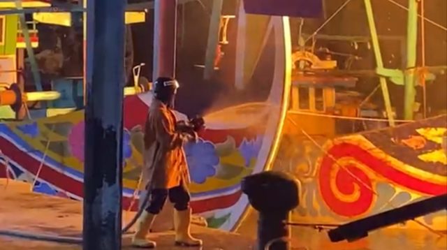Petugas Damkar berupaya memadamkan api yang membakar KMN Sri Sumber Rejeki di Dermaga PPN Brondong.