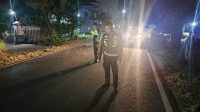 Petugas kepolisian saat melakukan olah TKP kecelakaan sepeda motor dan mobil di ruas jalan umum Desa Aryojeding, Kecamatan Rejotangan, Tulungagung.