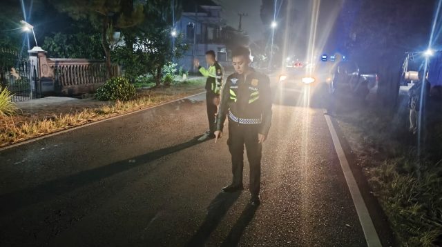 Petugas kepolisian saat melakukan olah TKP kecelakaan sepeda motor dan mobil di ruas jalan umum Desa Aryojeding, Kecamatan Rejotangan, Tulungagung.