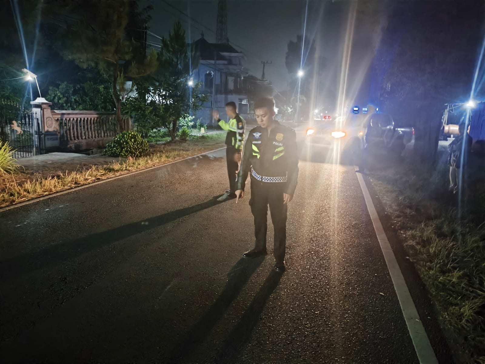 Petugas kepolisian saat melakukan olah TKP kecelakaan sepeda motor dan mobil di ruas jalan umum Desa Aryojeding, Kecamatan Rejotangan, Tulungagung.