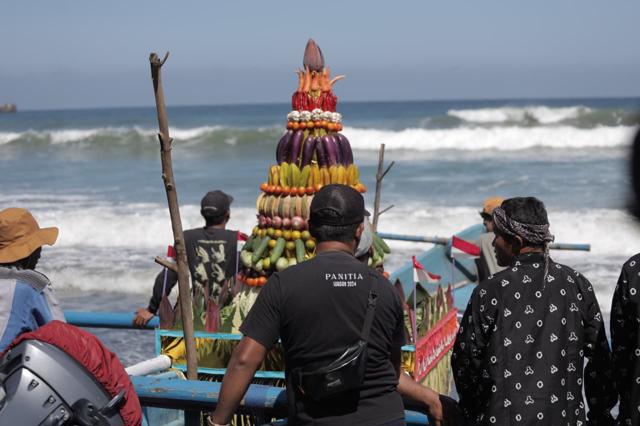 Sejumlah warga dan nelayan ketika melarung sesajen ke tengah laut di Pantai Serang, Kecamatan Panggungrejo. (foto: abdul aziz wahyudi)