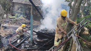 Petugas Damkar Ngadiluwih padamkan api yang membakar tumpukan kayu di Kraton Mojo Senin siang.