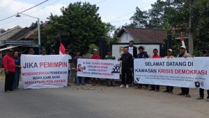 Warga bersama sejumlah Ketua RT membentangkan spanduk berisi kritik terhadap kebijakan pemerintah desa di perempatan Desa Duwet, Kecamatan Wates, Kabupaten Kediri.