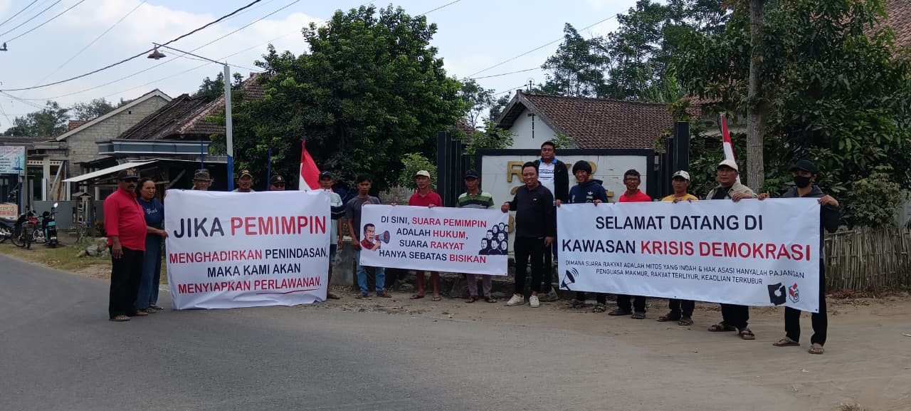 Warga bersama sejumlah Ketua RT membentangkan spanduk berisi kritik terhadap kebijakan pemerintah desa di perempatan Desa Duwet, Kecamatan Wates, Kabupaten Kediri.