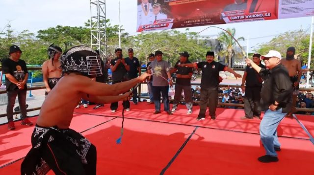 Bupati Rijanto ketika menjajal  mencambukkan  cemeti ke pemain.