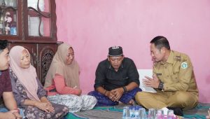 Bupati Lamongan Yuhronur Efendi menyerahkan santunan jaminan kecelakaan kerja kepada keluarga korban.