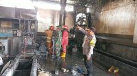 1002955770 Babinsa Koramil 11/Sumobito, Serda Priyo, bersama sejumlah karyawan dan tim pemadam kebakaran memadamkan api di Pabrik Plastik, Rabu (16/9/2026).