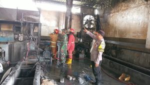 Babinsa Koramil 11/Sumobito, Serda Priyo, bersama sejumlah karyawan dan tim pemadam kebakaran memadamkan api di Pabrik Plastik, Rabu (16/9/2026).