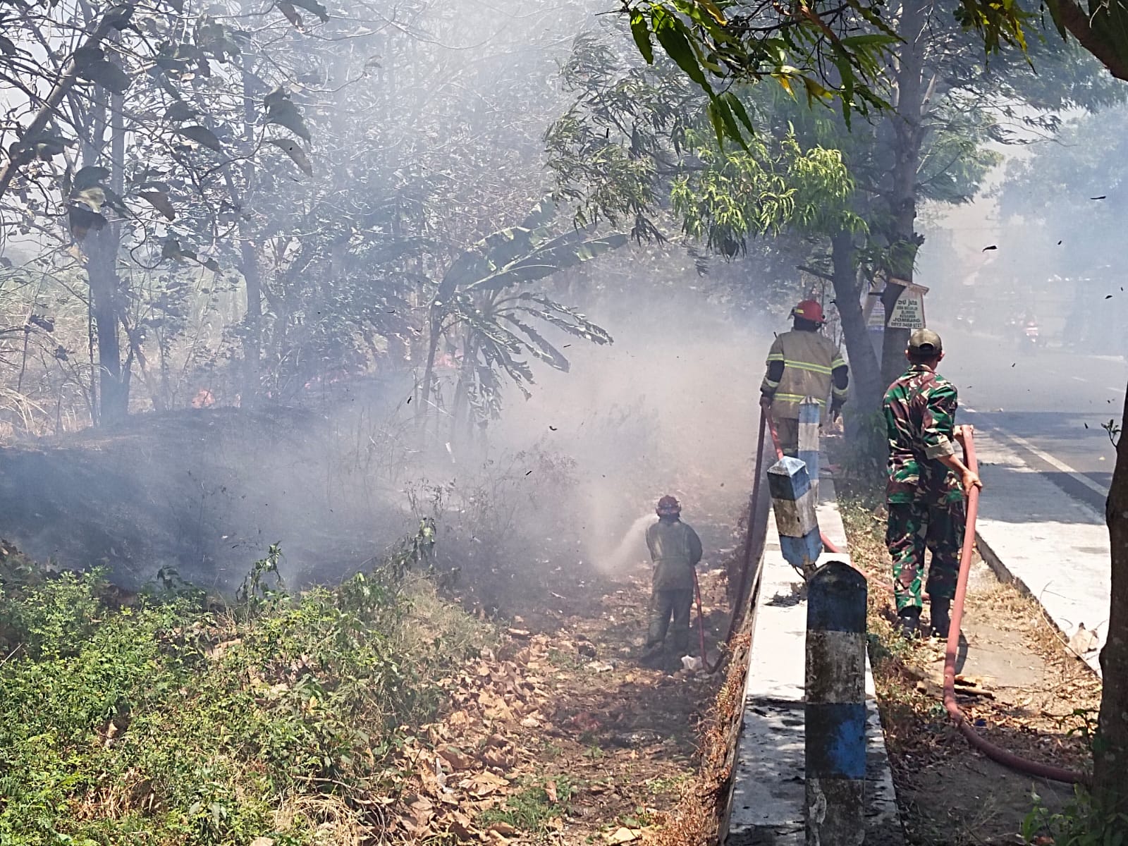 Petugas Pemadam Kebakaran (Damkar) dari BPBD Jombang saat memadamkan api yang membakar lahan tebu di Dusun Kedungwesi, Desa Talunkidul, Kecamatan Sumobito, Kabupaten Jombang, Jumat (25/9/2026).