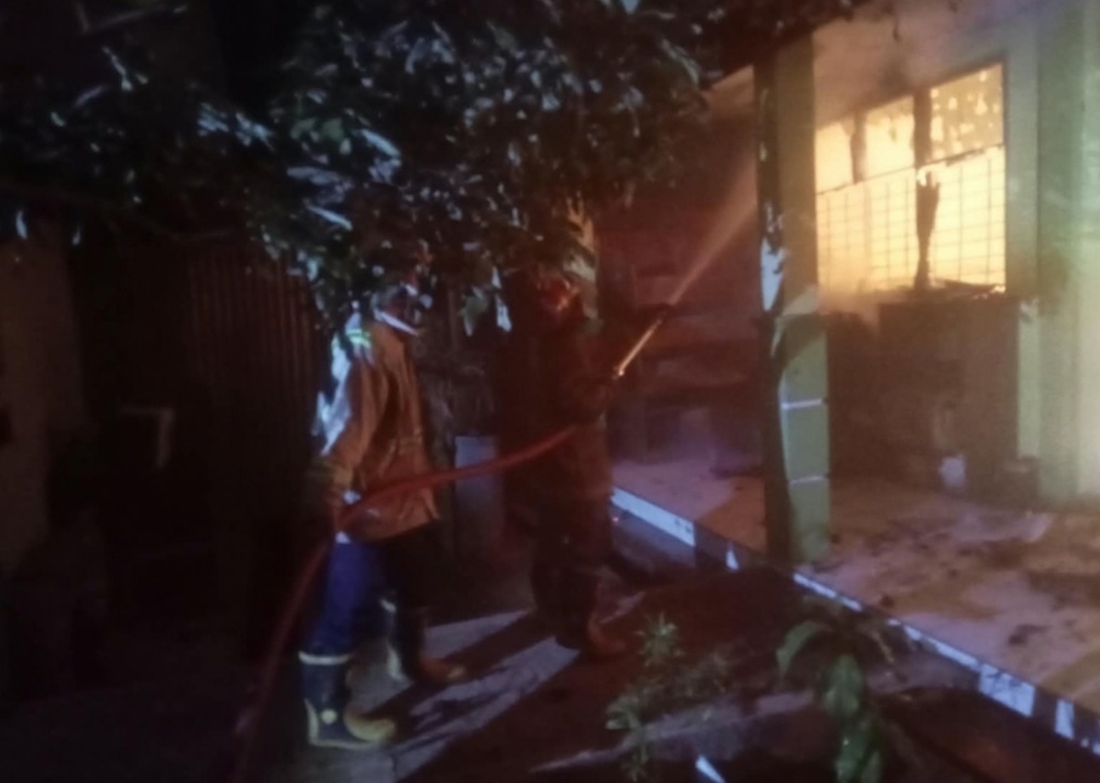 Petugas damkar Jombang saat melakukan pemadaman ruang perpustakaan dan UKS di gedung SMPN 2 Perak beralamat di Dusun Ngrandu, Desa Cangkringrandu, Kecamatan Perak, Jombang, Jumat (25/9/2026) malam.
