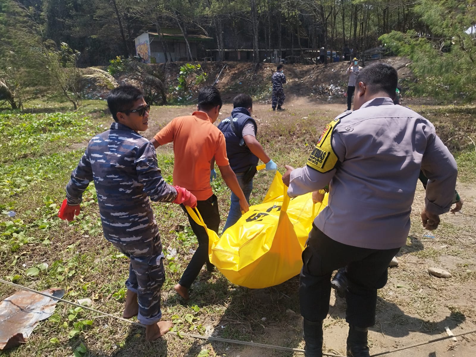 Petugas saat evakuasi jenazah dari sungai.