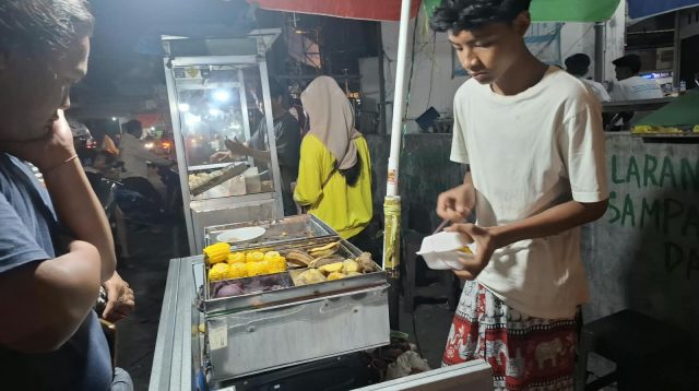 Ilham Putra Marselino saat berjualan jajanan tradisional Polo Pendem di Kawasan Tugu Wingko Babat Kecamatan Babat Kabupaten Lamongan.
