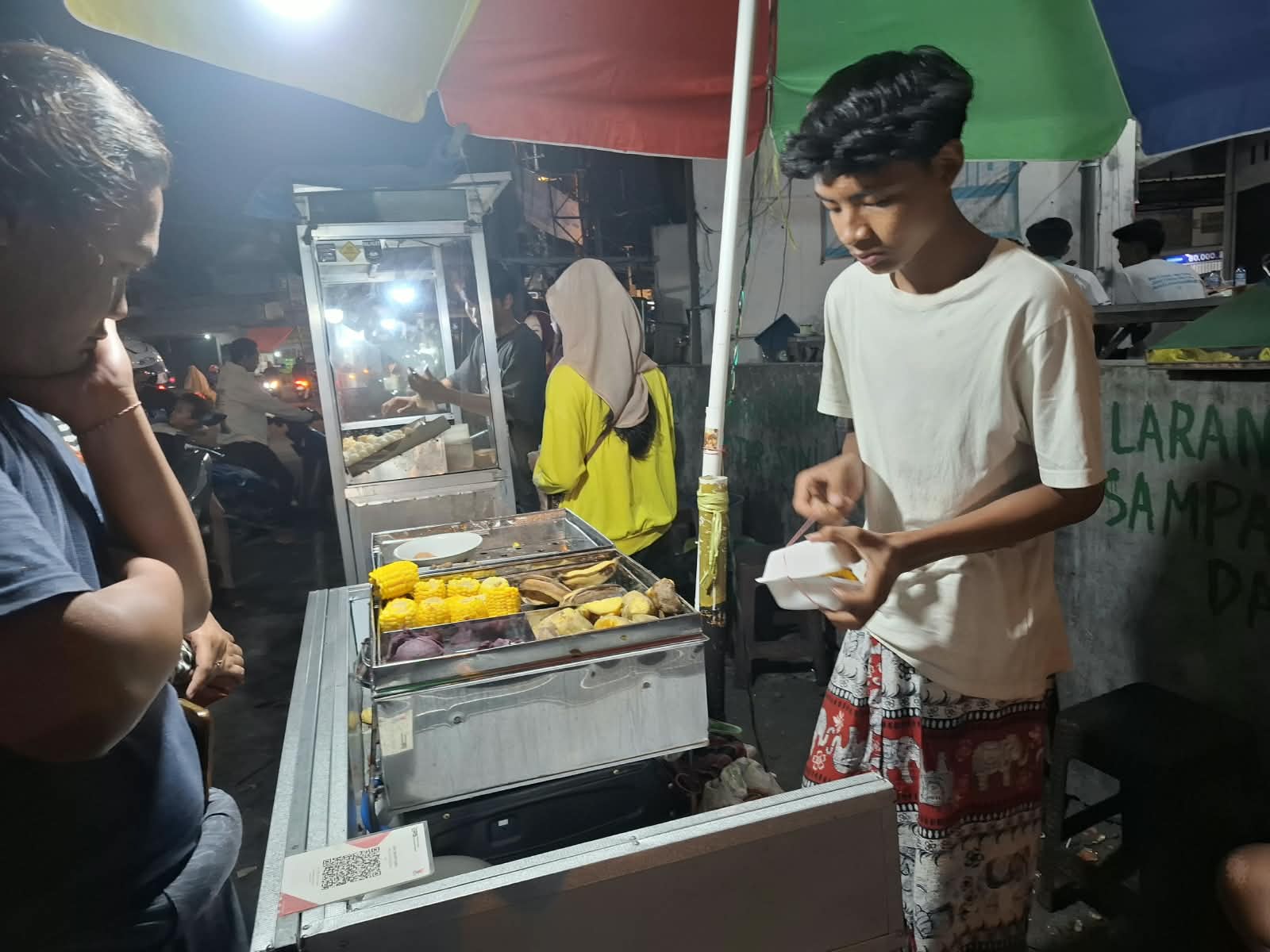 Ilham Putra Marselino saat berjualan jajanan tradisional Polo Pendem di Kawasan Tugu Wingko Babat Kecamatan Babat Kabupaten Lamongan.