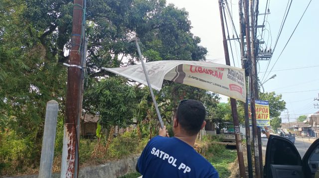 Anggota Satpol PP Ponorogo saat melakukan penertiban banner.