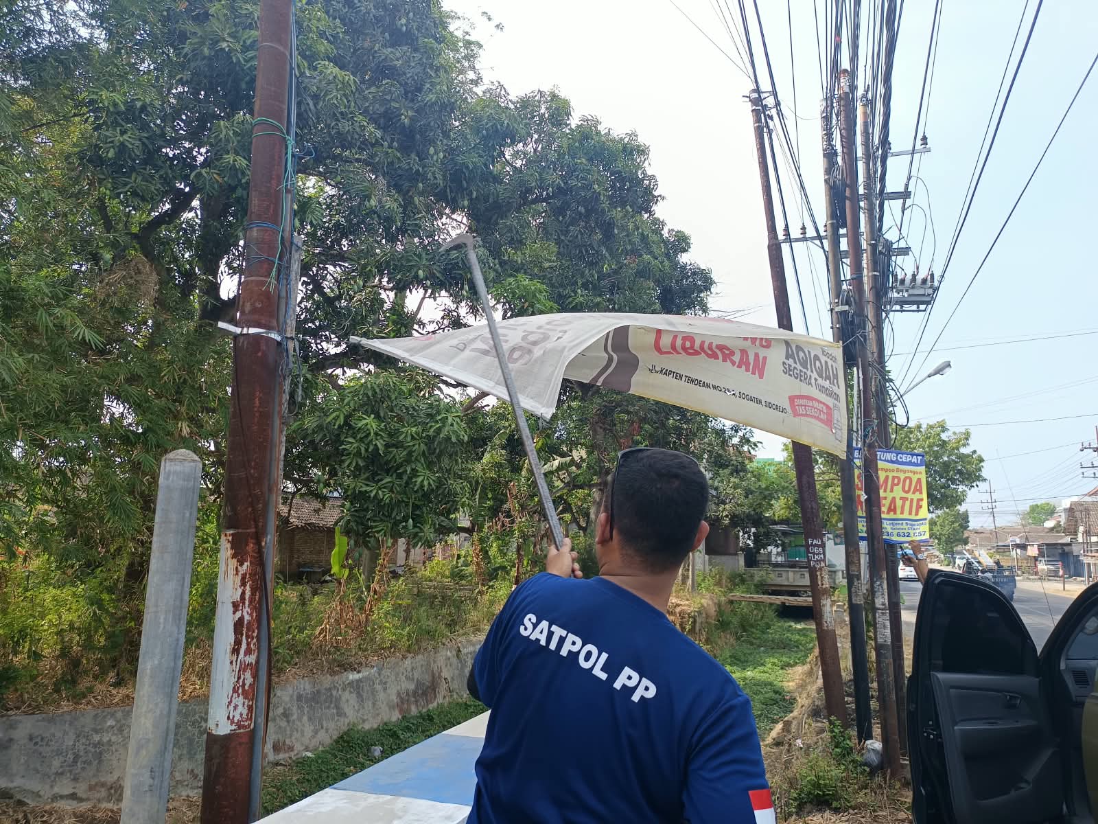 Anggota Satpol PP Ponorogo saat melakukan penertiban banner.